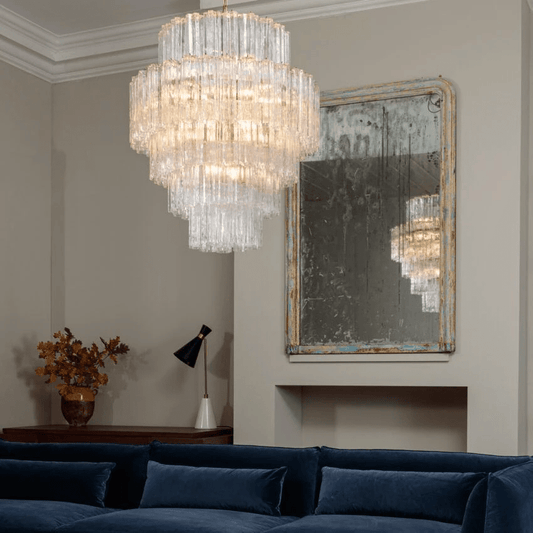 Clear Firenze Murano Glass Chandelier above a navy sofa in a high-ceiling living room