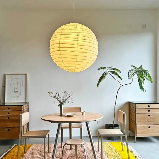 Round glowing rice paper pendant above a small dining area