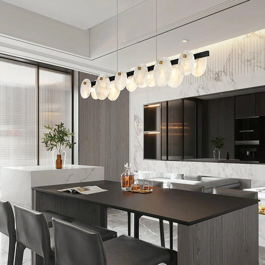 Lunar Glow Alabaster Chandelier above a dark kitchen island in a marble interior