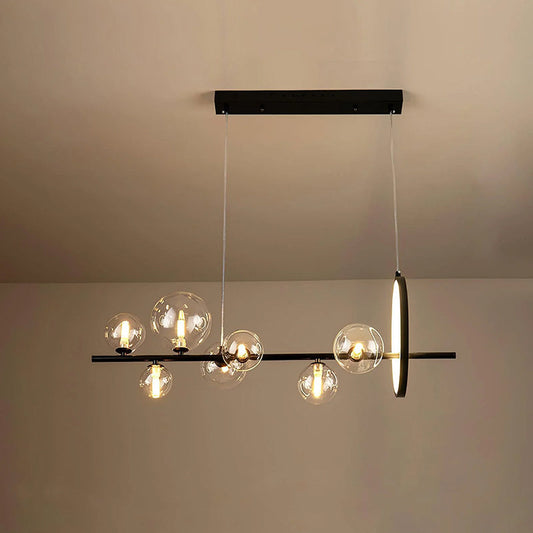 Modern linear glass globe chandelier over a dining table