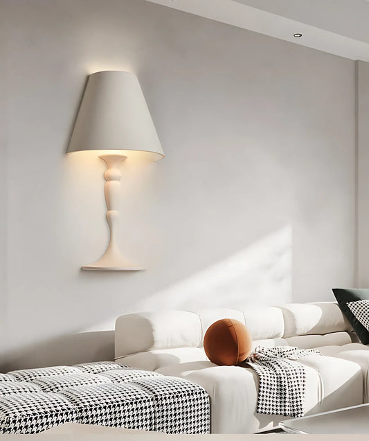 Wall sconce providing ambient light above a bed