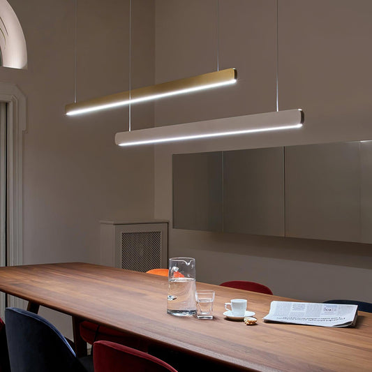 Faretto linear pendant above a long worktable with documents and chairs