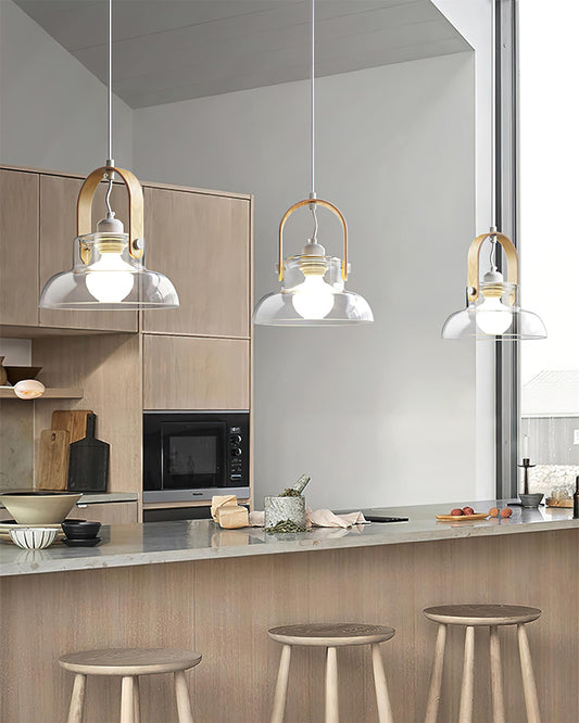 Three clear glass pendants above an open kitchen island with accessible floor space