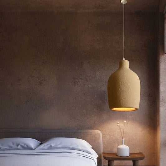 Hana pendant hanging beside a bed in a warm neutral bedroom