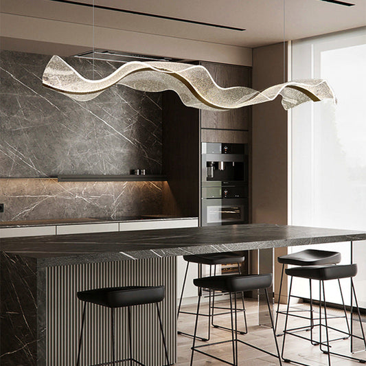 Acrylic Ribbon Chandelier suspended above a dark stone kitchen island
