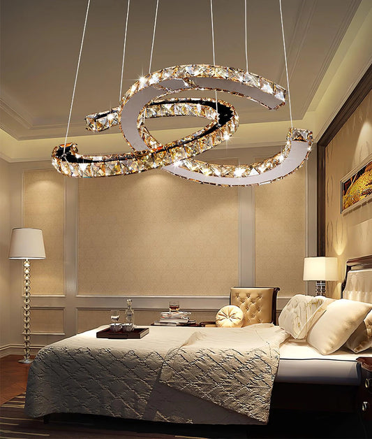 Warm amber Modern Double C Crystal Chandelier above a bed in a neutral bedroom