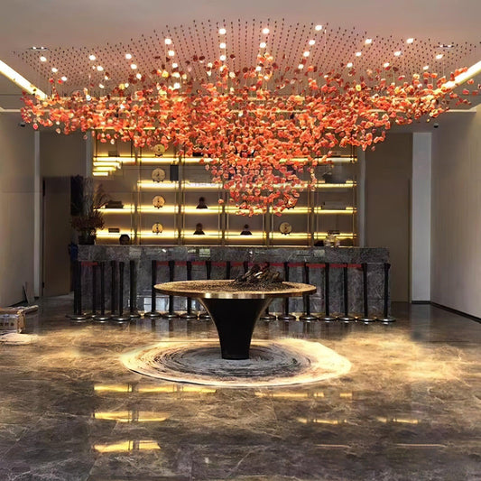 Large orange crystal installation suspended above an open hotel lobby floor