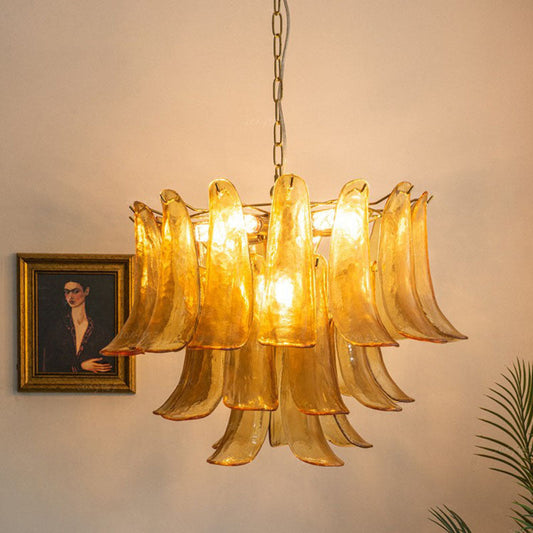 Amber Murano Glass Chandelier reflected in a mirror above a red sofa and wood cabinet