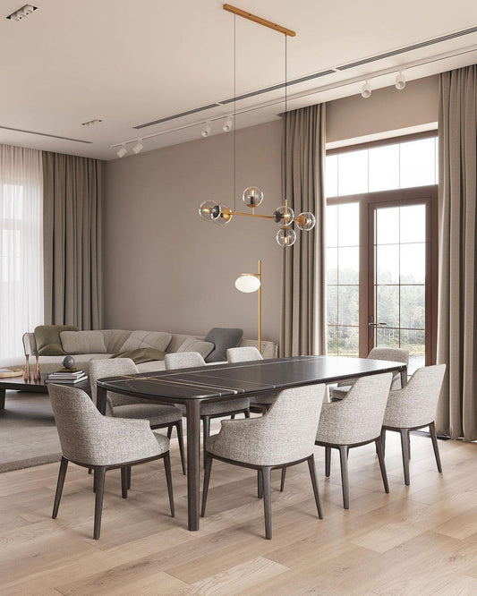 Orb Chandelier extending across an open dining and living room with tall windows